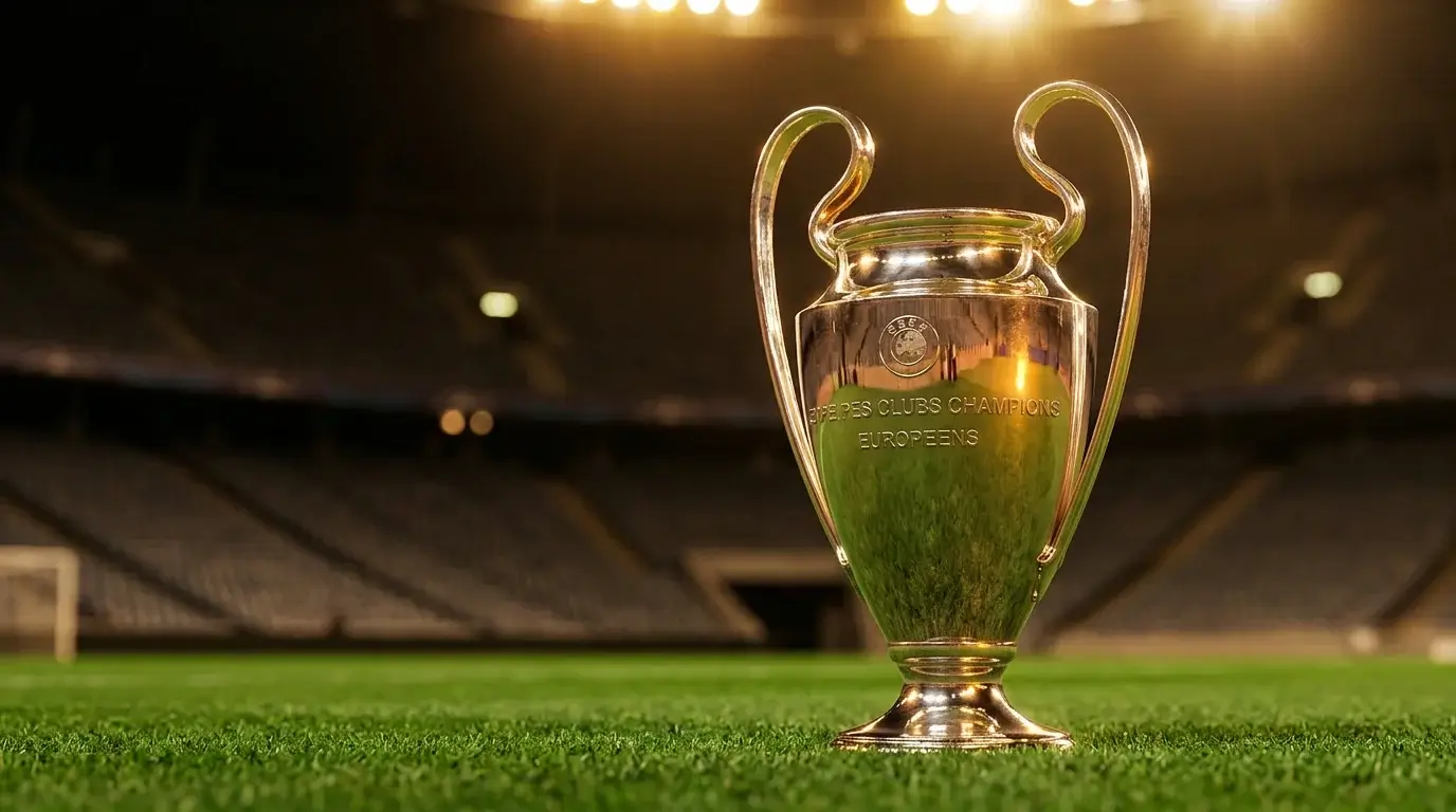 Trofeo de la Champions League iluminado sobre cesped europeo