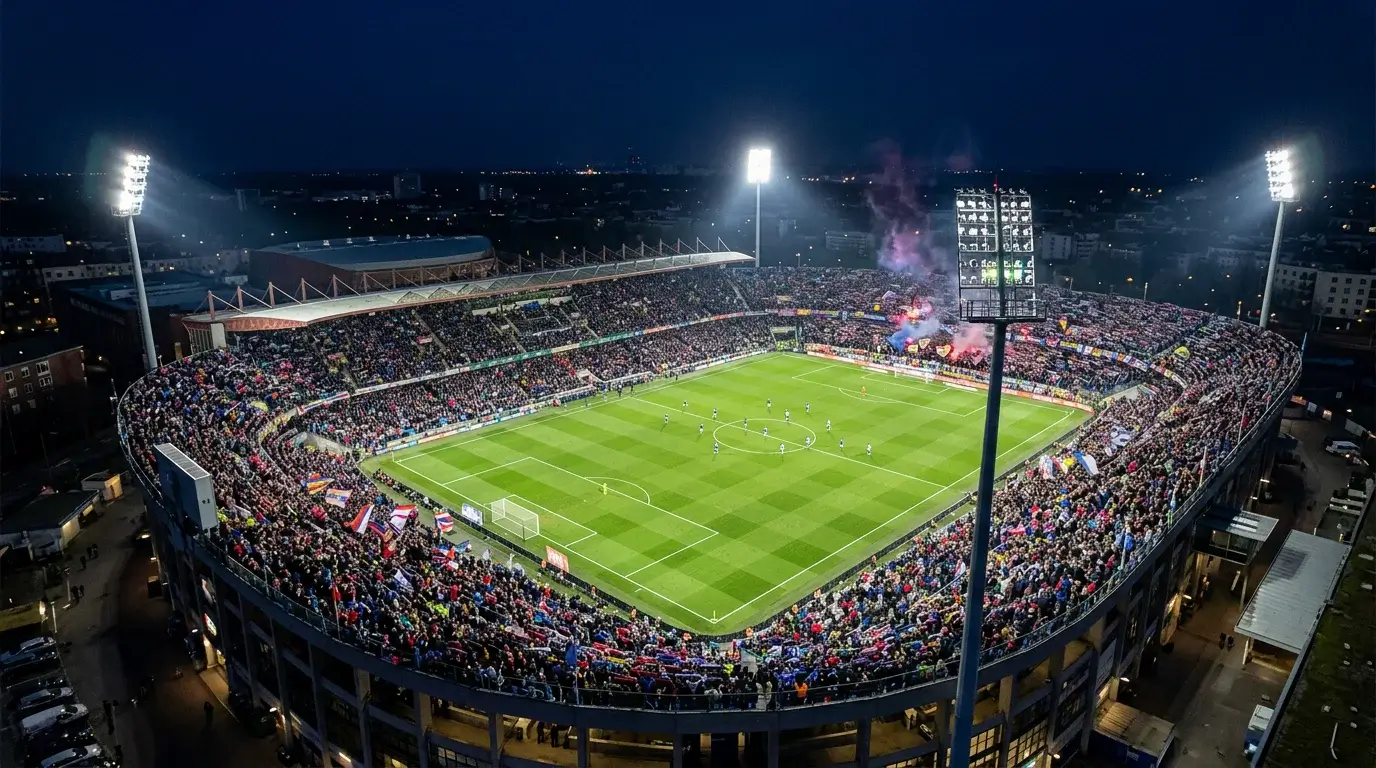 Vista panoramica de un estadio de futbol europeo lleno de espectadores durante un partido nocturno de Champions League